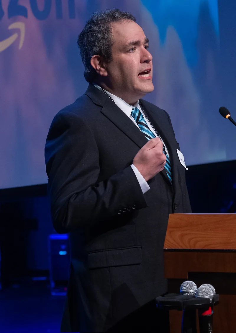 Josh mid-sentence at the lectern during the Covington Storehouse Gala keynote